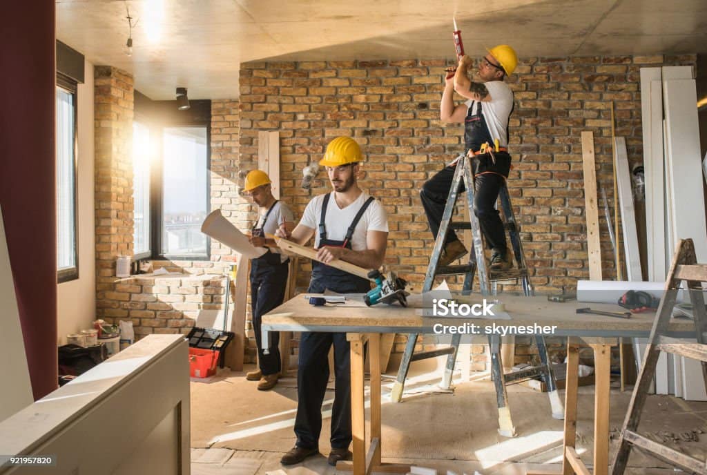 Busy construction workers working on home improvement in the apartment.